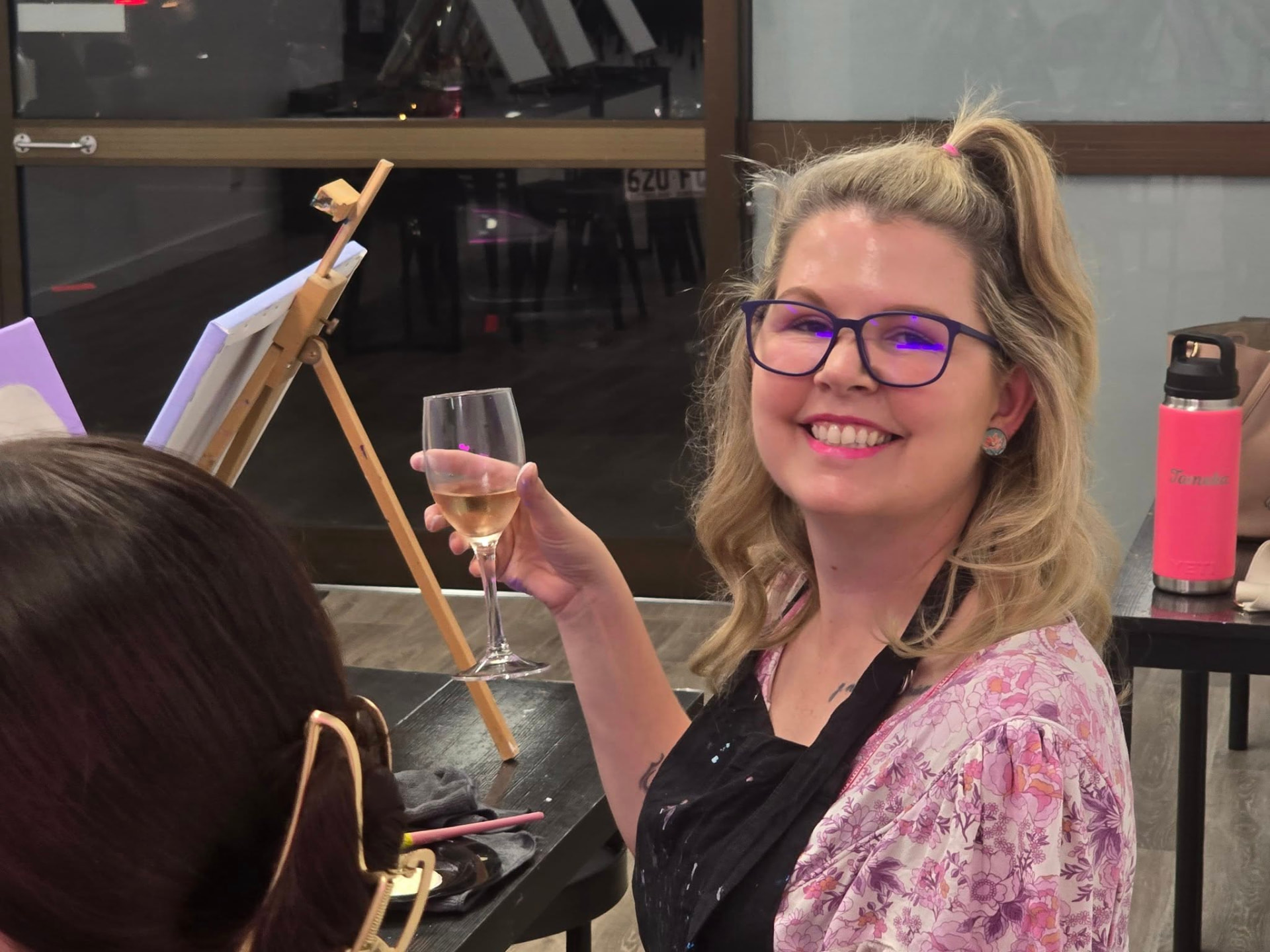 Guest cheersing with wine while painting